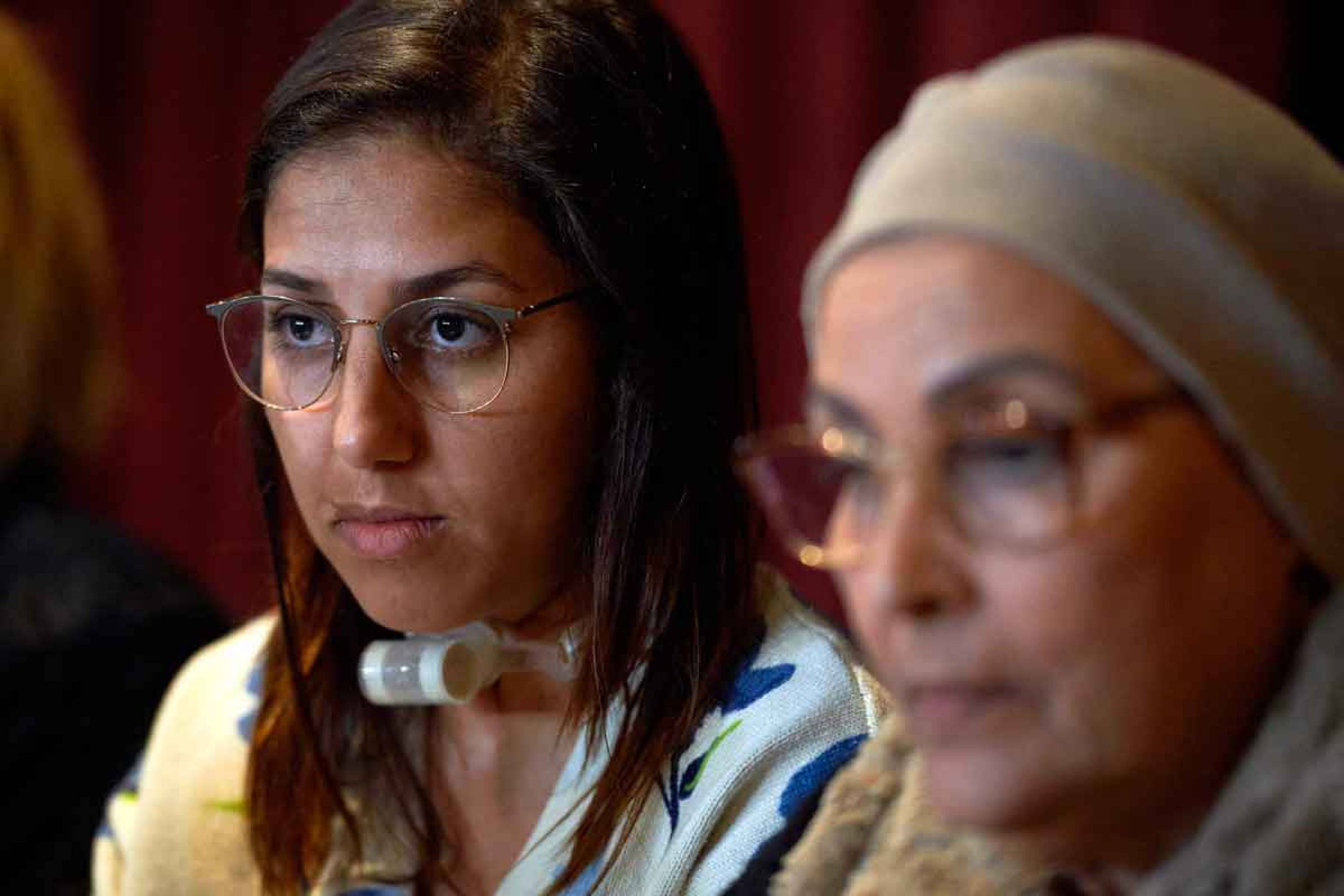 Saada Arbane usa cânula para respirar e falar, depois de ter a garganta cortada por jihadista Saada Arbane, usando cânula no pescoço, é fotografada durante audiência em tribunal