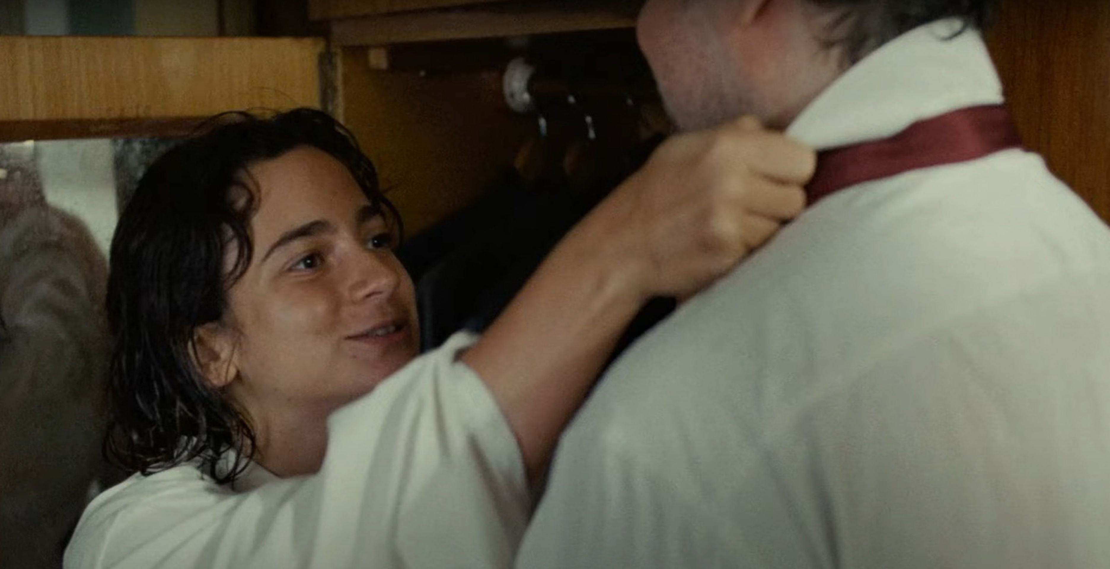 Atriz Bárbara Luz põe gravata em Selton Mello em cena do filme Ainda estou aqui 