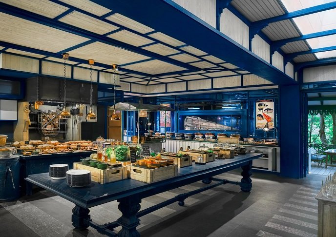 NÃ£o menos importante, o cafÃ© da manhÃ£ Ã© servido na Cozinha de Somying, um restaurante com cabines semelhantes aos tradicionais vagÃµes de jantar e decoraÃ§Ã£o interna toda em azul e branco. 