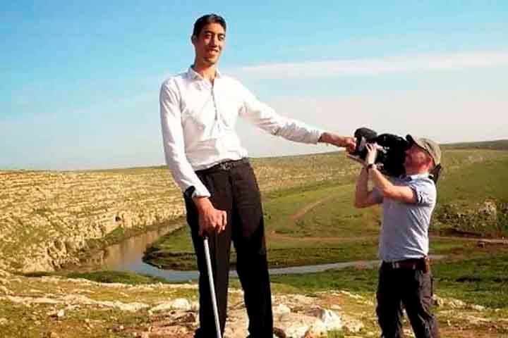 O homem mais alto do mundo precisa utilizar muletas para conseguir se locomover. 

