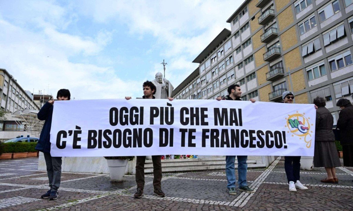  Membros do Movimento dos Trabalhadores Cristãos hasteiam faixa com os dizeres "Hoje mais do que nunca precisamos de você, Francisco" em frente ao Gemelli, onde o Papa está internado -  (crédito: Tiziana FABI / AFP)