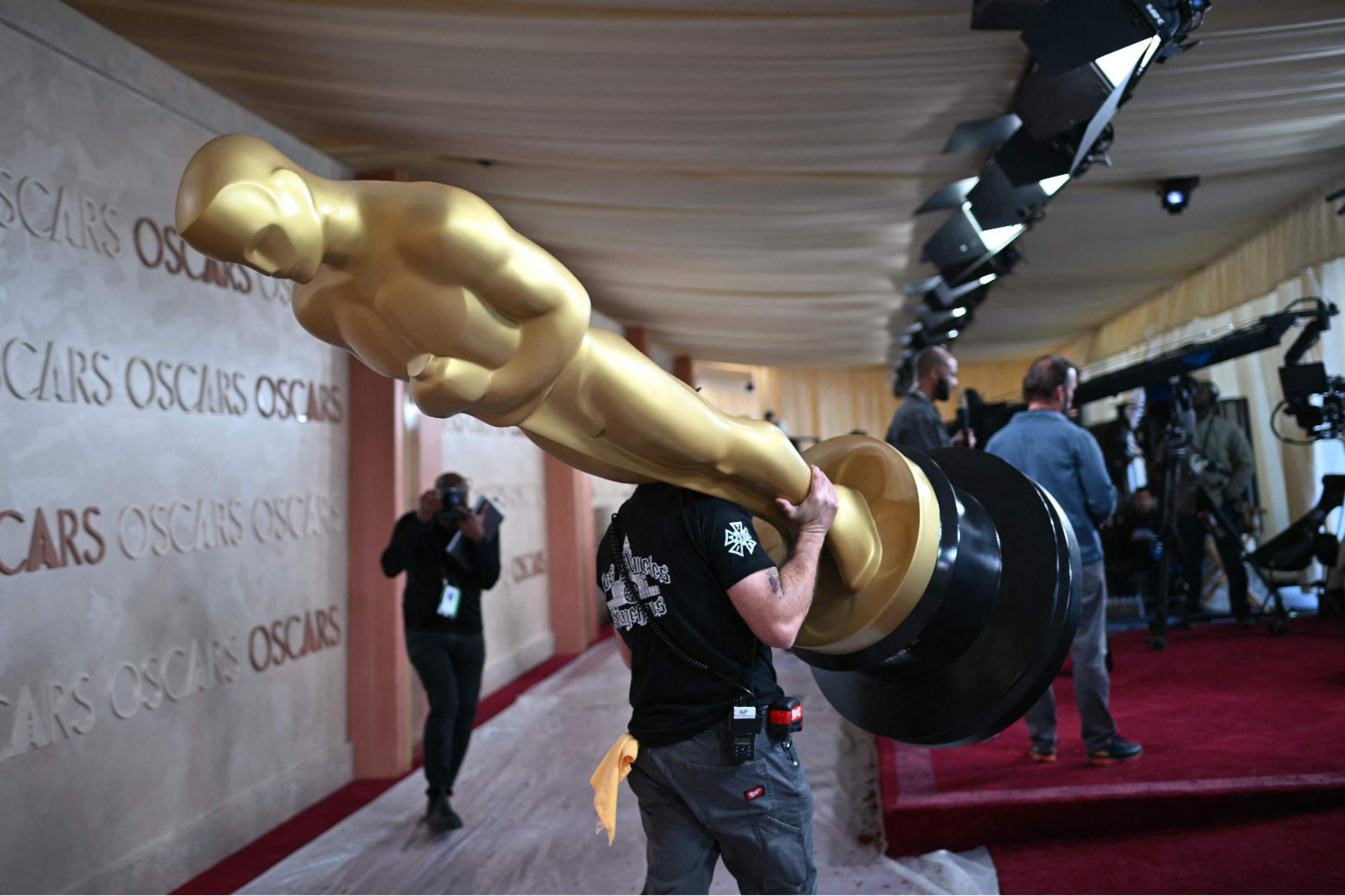 Funcionários carregam a estátua do Oscar durante os preparativos do Dolby Theatre, em Los Angeles, para receber a cerimônia do Oscar neste domingo (2/3) 