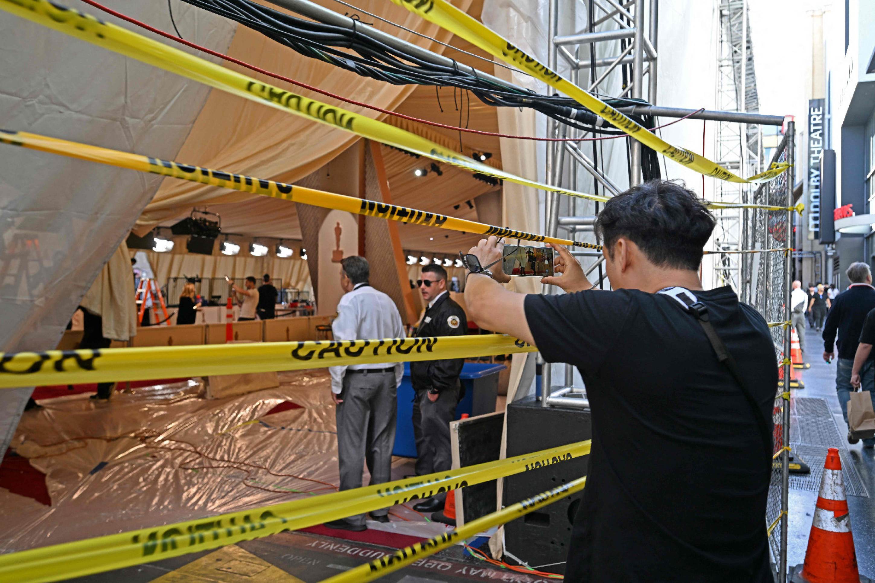 Pessoas tiram fotos da área do tapete vermelho do Dolby Theatre, em Los Angeles, por onde passarão astros e estrelas do Oscar 2025, cuja premiação ocorrerá neste domingo (2/3)