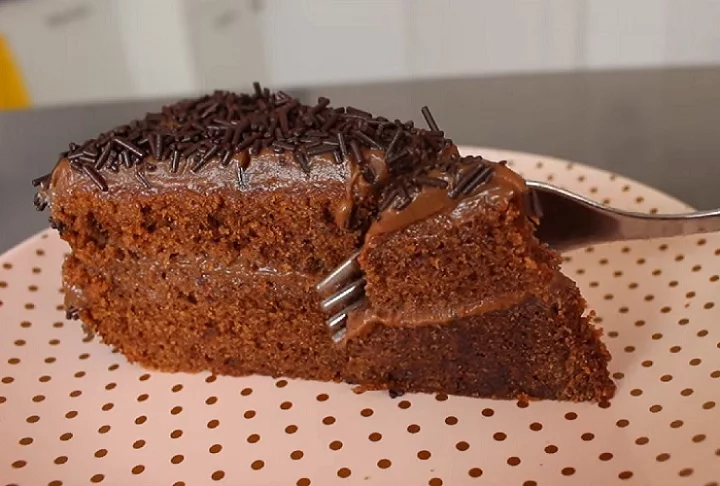 Preparado com chocolate ao leite e finalizado com uma camada generosa de brigadeiro cremoso, o guia ressalta tanto a facilidade de preparo quanto o sabor irresistível do bolo.-reprodução/youtube La Dolce Rita