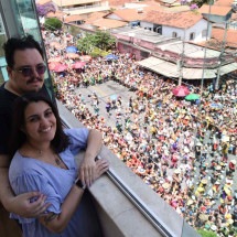 Do alto do prédio, casal acompanha o desfile do Estagiários Brass Band - Gladyston Rodrigues/EM/D.A