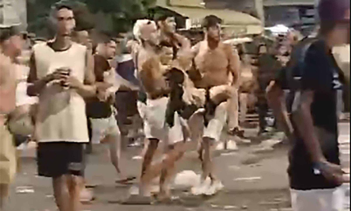 Multidão em pânico com o tiroteio e ferido sendo socorrido por populares em Rio Pomba
