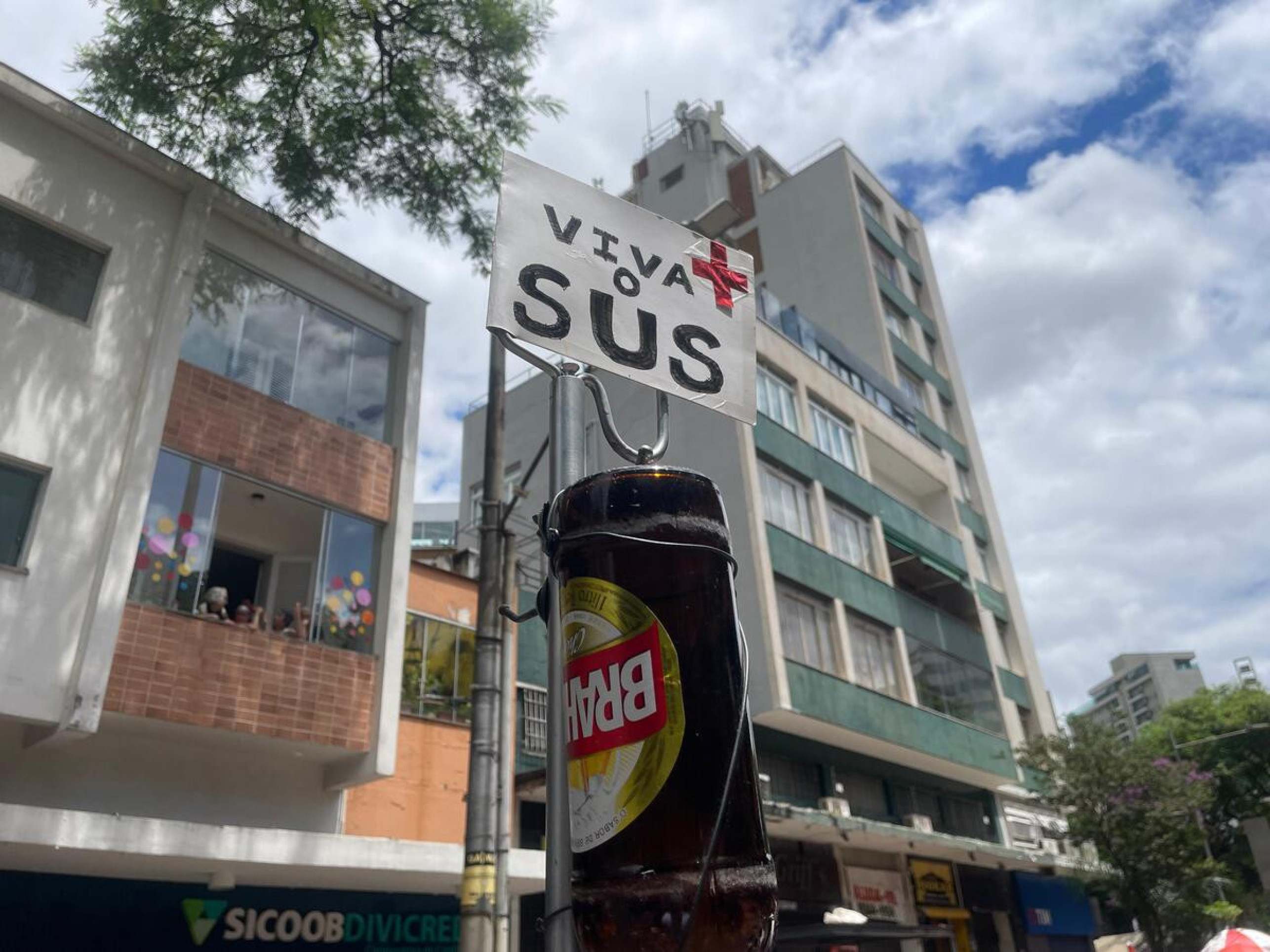 No topo do carrinho hospitalar, o soro foi substituído por uma cerveja, e uma placa no topo celebra: 'Viva o SUS'-Denys Lacerda/EM/D.A Press