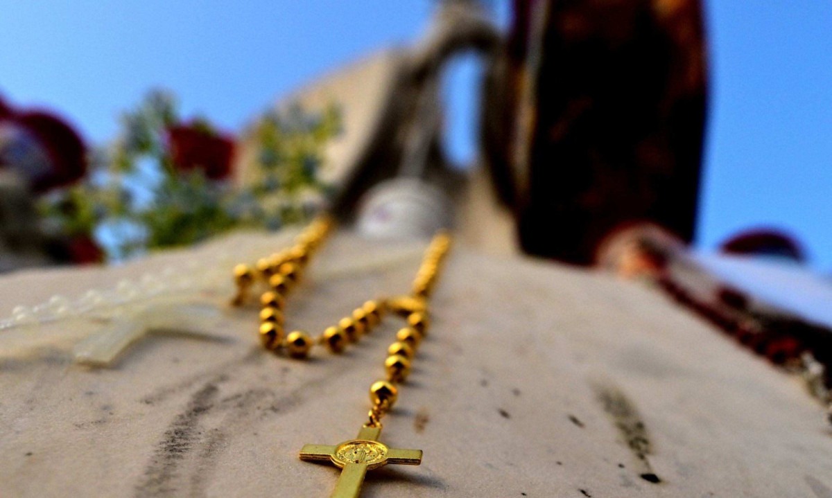 Crucifixo pendurado na estátua de João Paulo II do lado de fora do Hospital Universitário Gemelli, onde o Papa Francisco está hospitalizado com pneumonia, em Roma -  (crédito: TIZIANA FABIAFP)