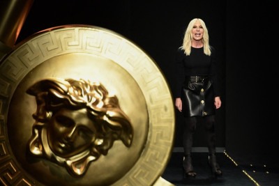 Donatella Versace ao lado da famosa Medusa da marca italiana durante desfile em Milão, em 2019 -  (crédito: Miguel Medina/AFP)