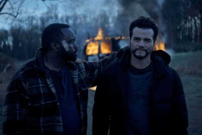 Ray (Brian Tyree Henry) e Manny (Wagner Moura) usam distintivos falsos e fingem ser agentes para roubar pequenos traficantes
 -  (crédito: Apple/Divulgação)