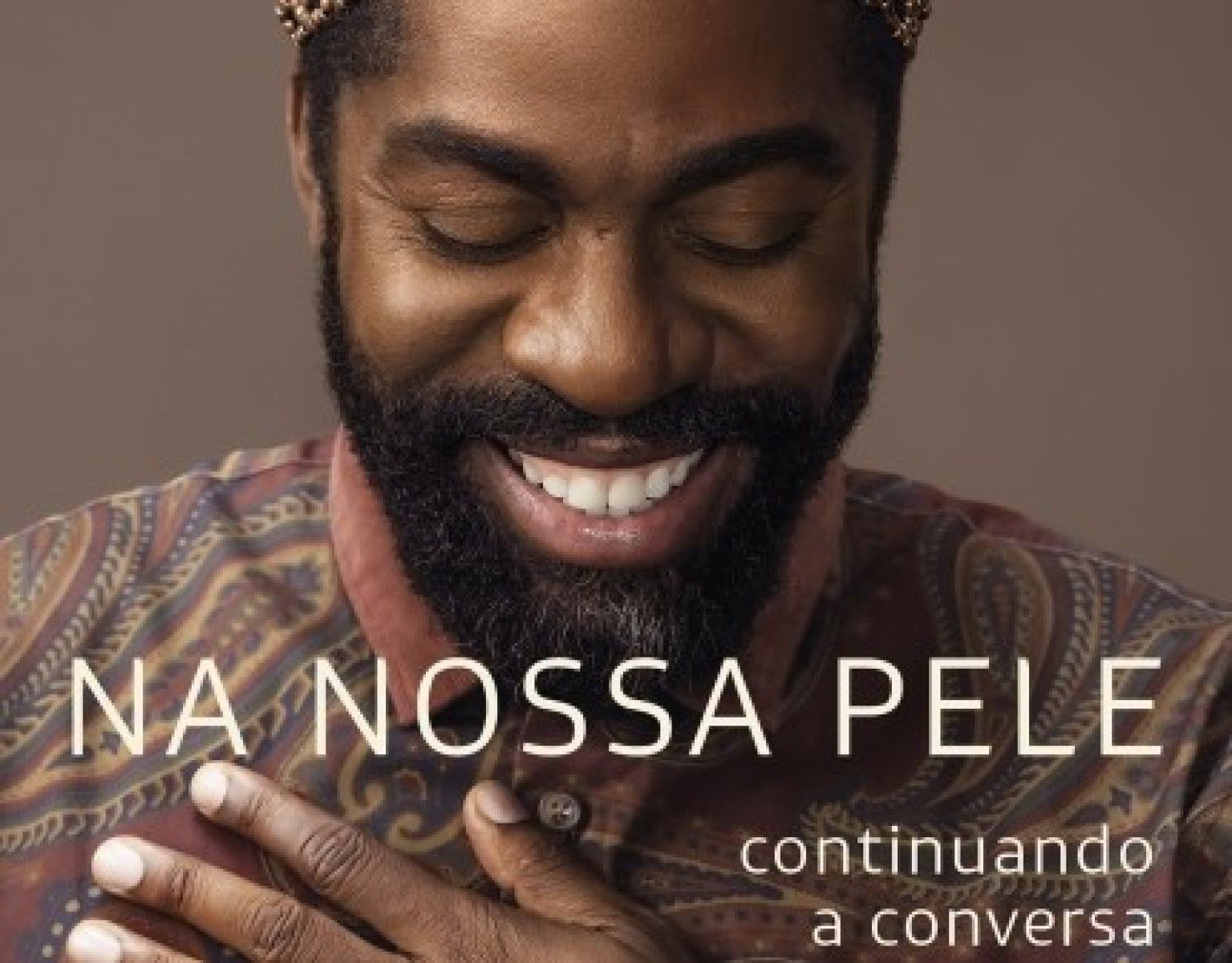 Lázaro Ramos sorri na capa de seu livro Na nossa pele