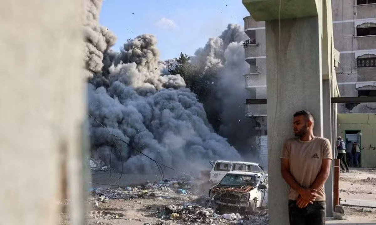 Homem se protege durante ataque israelense em Zeitoun, Gaza, em 1º de setembro de 2024 -  (crédito:  Omar AL-QATTAA / AFP)