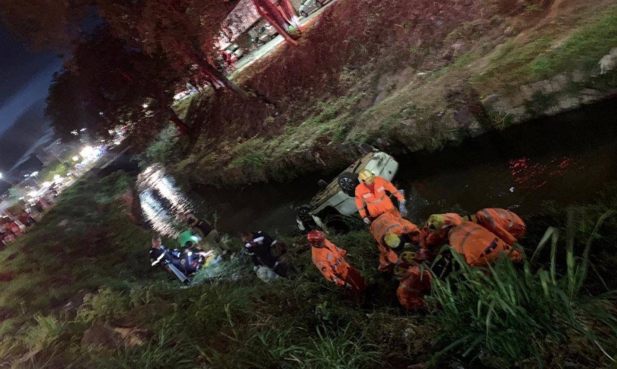 Carro submerso no Rio Betim após acidente que deixou uma mulher morta e três feridos em Contagem, na Grande BH -  (crédito: Corpo de Bombeiros/Divulgação)