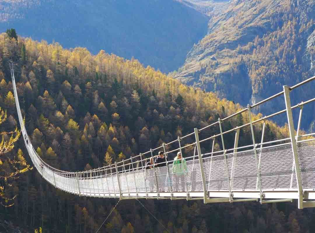 Charles Kuonen, Suíça: Inaugurada em 2017, essa ponte se estende por 494 metros no coração dos Alpes Suíços, conectando as cidades de Randa e Zermatt. Ela ostentou o título de mais longa do mundo para pedestres até 2022.