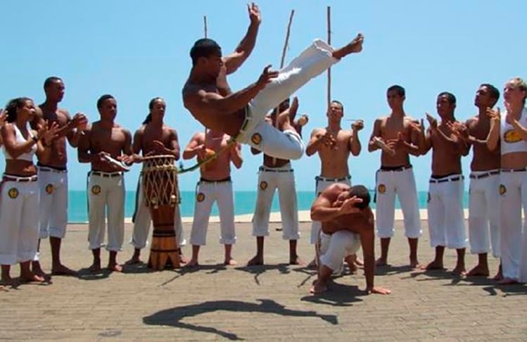 Além de dança, a capoeira é defesa. O objetivo é demonstrar força, habilidade e autoconfiança, com perfeição no gingado (movimento ritmado do corpo, com equilíbrio e atenção nos movimentos de esquiva, ataque e contra-ataque do parceiro). -reprodução todamateria.com.br