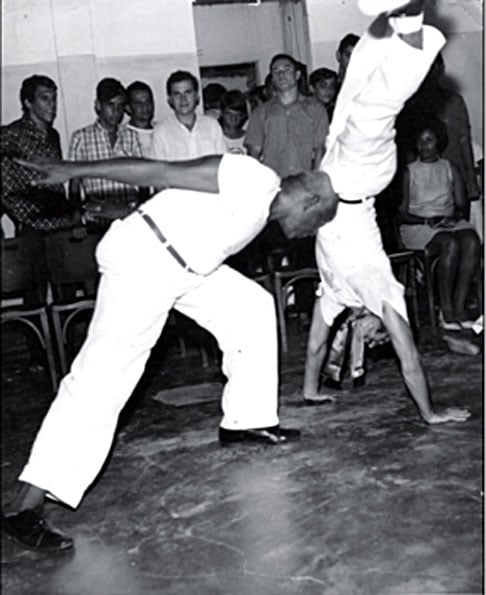 Nos anos 1930, Mestre Bimba tinha percebido que a capoeira, como luta, estava perdendo adeptos.  Muitos a consideravam violenta. Então, ele misturou elementos da Capoeira Tradicional com o batuque criando um novo estilo, com movimentos mais rápidos, num ritmo musical contagiante. -Reprodução do site 
multirio.rj.gov.br/index.php/leia/reportagens-artigos/reportagens