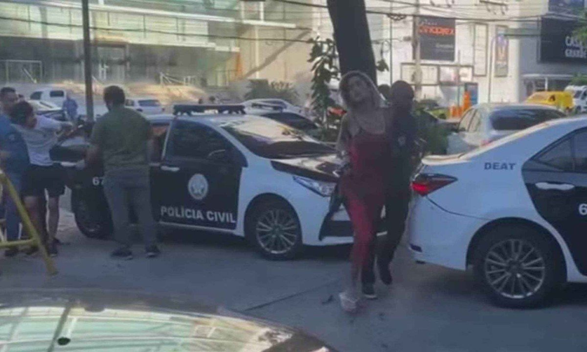Policiais conduzem à delegacia uma das suspeitas de extorsão de turista no Rio de Janeiro -  (crédito: Reprodução/redes sociais)