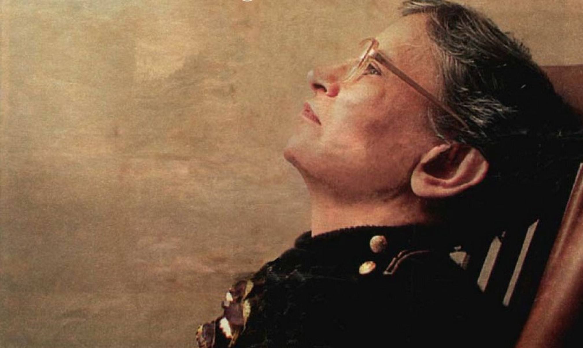 A poeta Orides Fontela está de lado, recostada em cadeira
