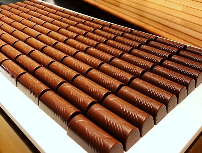 Os suíços não foram os primeiros europeus a fazer chocolate, mas foram os primeiros a adicionar leite, criando o chocolate como conhecemos hoje.-Reprodução do site 99destinos.com.vc/delicias-na-suica-visitando-a-fabrica-da-nestle-maison-cailler-e-a-fabrica-do-queijo-gruyere/