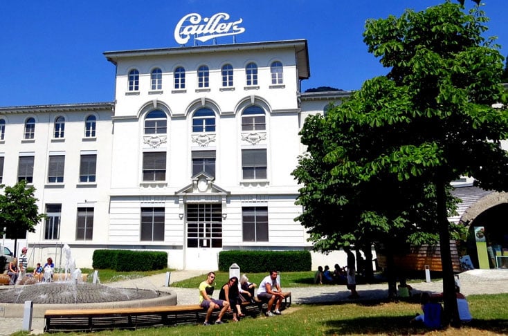 A fabricante suÃ­Ã§a Cailler foi quem criou o primeiro chocolate ao leite, em 1875, adicionando leite em pÃ³ Ã  preparaÃ§Ã£o.-ReproduÃ§Ã£o do site fuipraeuropa.com.br/2013/11/10/chocolates-suicos-visita-a-maison-cailler-nestle/