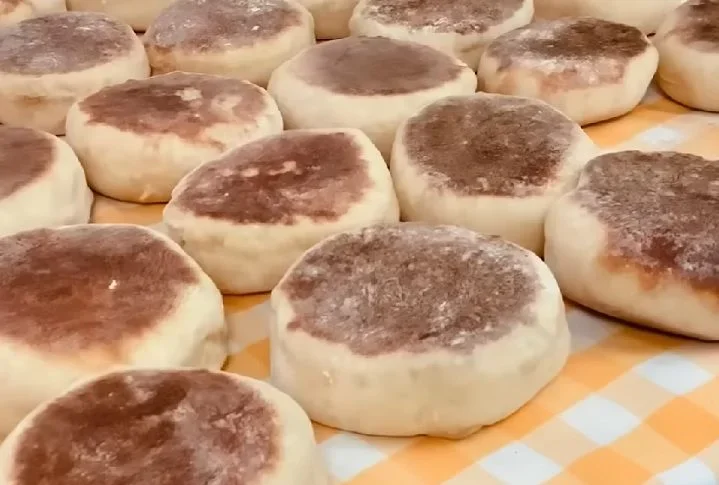 Esses pães são redondos, macios e ligeiramente doces, com uma textura semelhante à de um pão de hambúrguer, mas mais denso e com sabor marcante.
