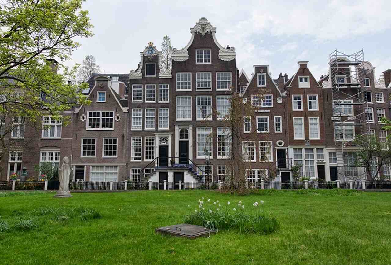 Begijnhof - Descrição: Um dos segredos mais bem guardados de Amsterdã, o Begijnhof é um pátio tranquilo e histórico, fundado no século XIV, que serviu como residência para as Beguinas, mulheres religiosas que viviam em comunidade sem votos monásticos - Localização: Próximo à Praça Spui - Referências Históricas: A capela e as casas no Begijnhof são alguns dos edifícios mais antigos da cidade-Jean-Christophe BENOIST/Wikimedia Commons