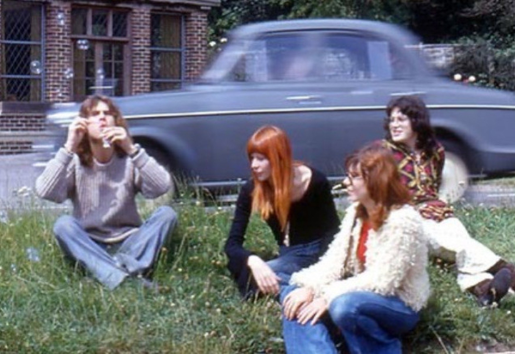Ritchie sentado na grama em Londres com Rita Lee, que o convidou para conhecer o Brasil, Leila Lisboa e Lucinha Turnbull