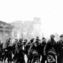 prisioneiros de guerra alemães são conduzidos pelo portão de Brandemburgo e passam por um   tanque IS-11 a caminho de seu cativeiro. Os últimos prisioneiros se renderiam à Alemanha em 1956