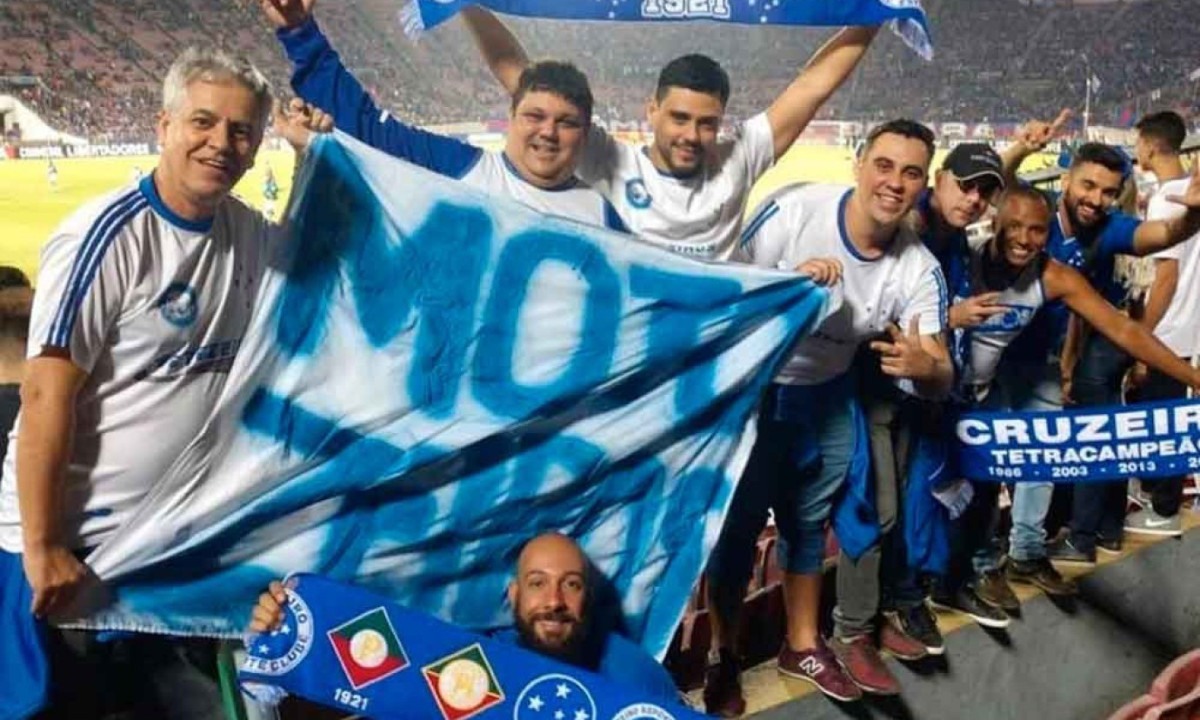 Délio (E) e a faixa improvisada da Torcida Motozeiros, em 2018, durante jogo da Raposa, em Santiago, capital do Chile, pela Copa Libertadores - (crédito: Motozeiros/divulgação) Délio (E) e a faixa improvisada da Torcida Motozeiros, em 2018, durante jogo da Raposa, em Santiago, capital do Chile, pela Copa Libertadores - (crédito: Motozeiros/divulgação)