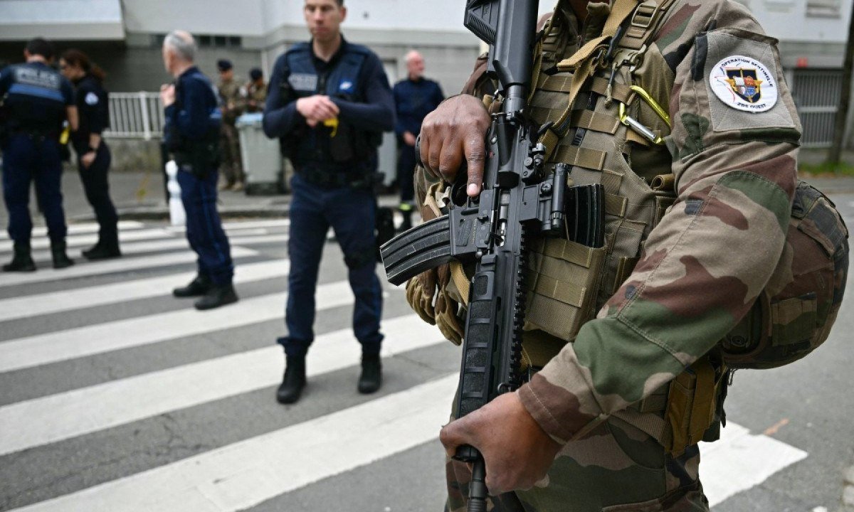 Militares, policiais e agentes da Polícia Municipal em torno da escola em Nantes, na França, onde um aluno matou outro e feriu três com uma faca
       -  (crédito: LOIC VENANCE / AFP)