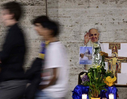  People walk past a makeshift altar with the portrait of late Pope Francis near the Vatican in Rome on April 24, 2025. The Vatican on April 24 said some 61,000 people had already paid their respects to Pope Francis, whose body is lying in state in St Peter's Basilica ahead of his funeral. (Photo by Tiziana FABI / AFP)
      