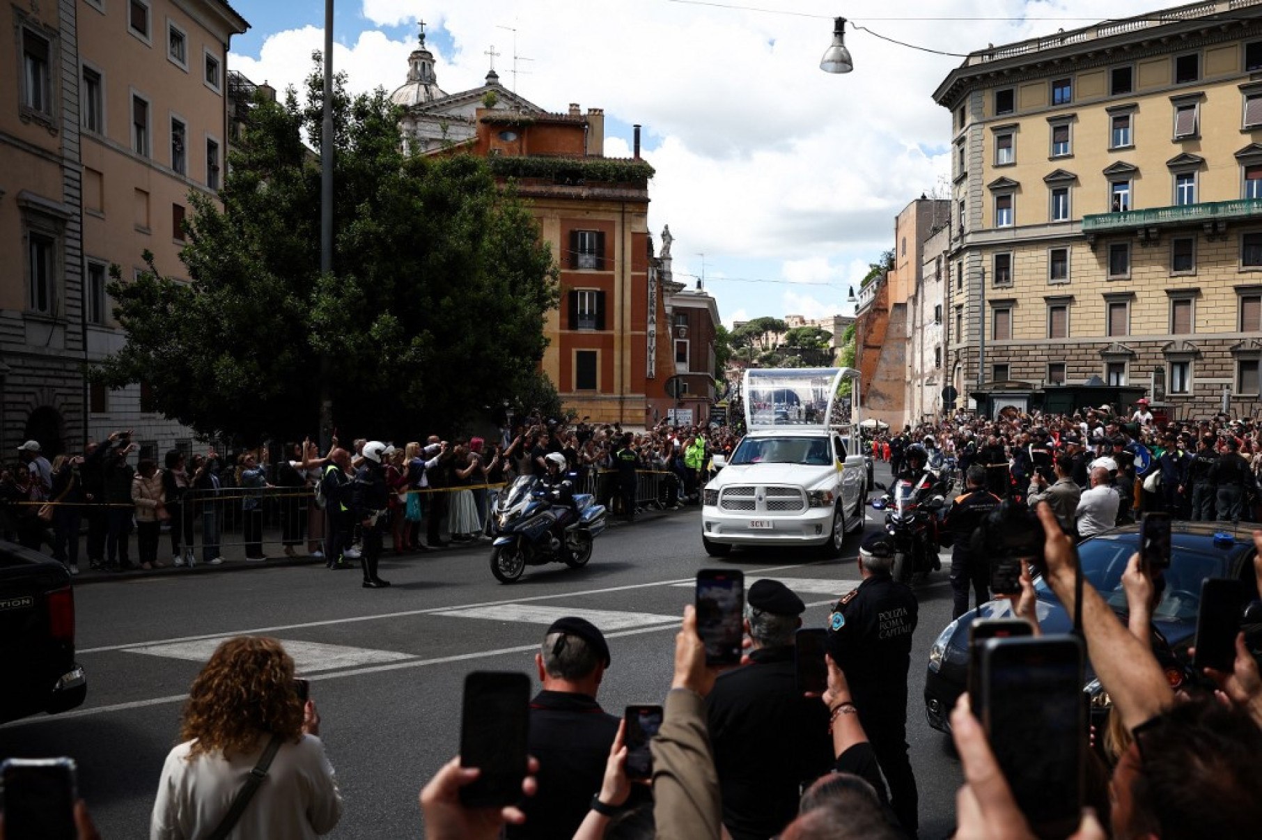 Fiéis tiram fotos com seus celulares do caixão enquanto papa é transportado de papamóvel da Basílica de São Pedro para a Basílica de Santa Maria Maggiore-HENRY NICHOLLS / AFP