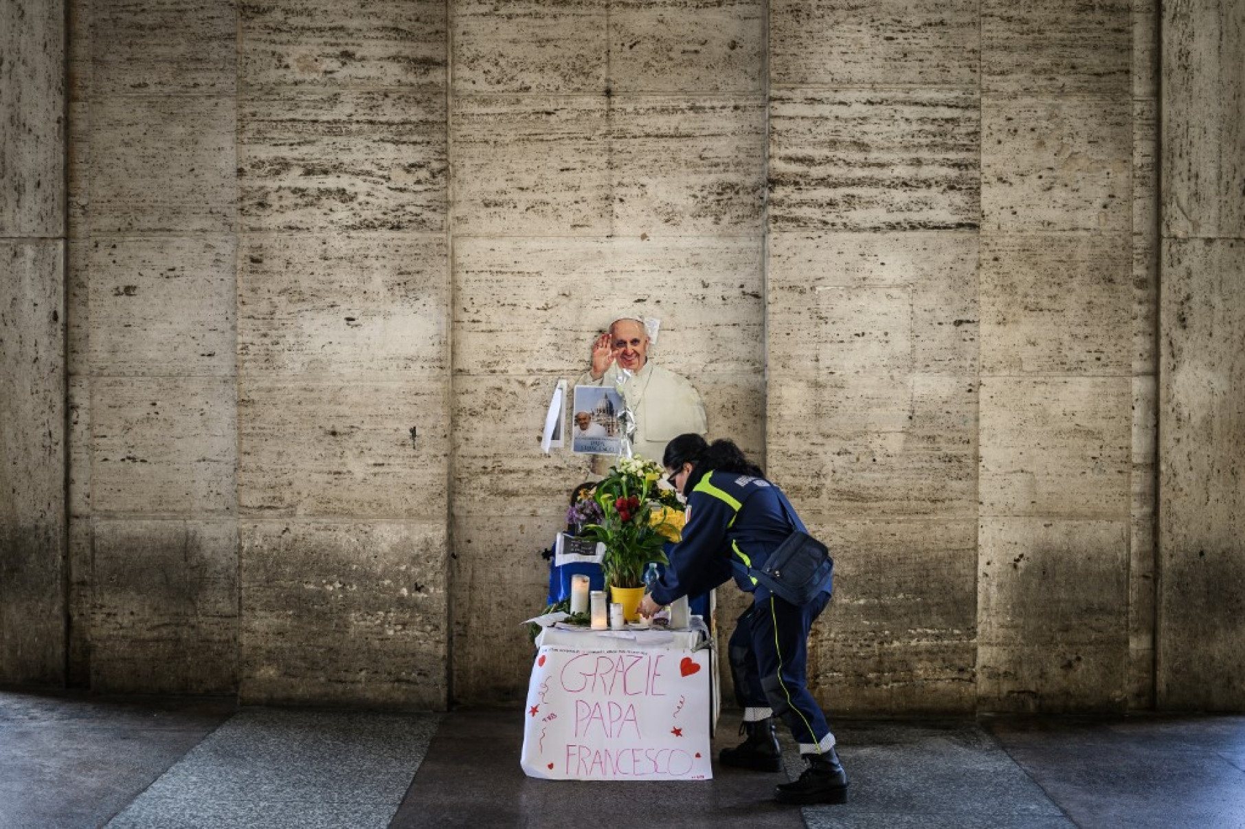 Voluntário acende uma vela no memorial do Papa Francisco durante o funeral do pontífice-JEFF PACHOUD / AFP