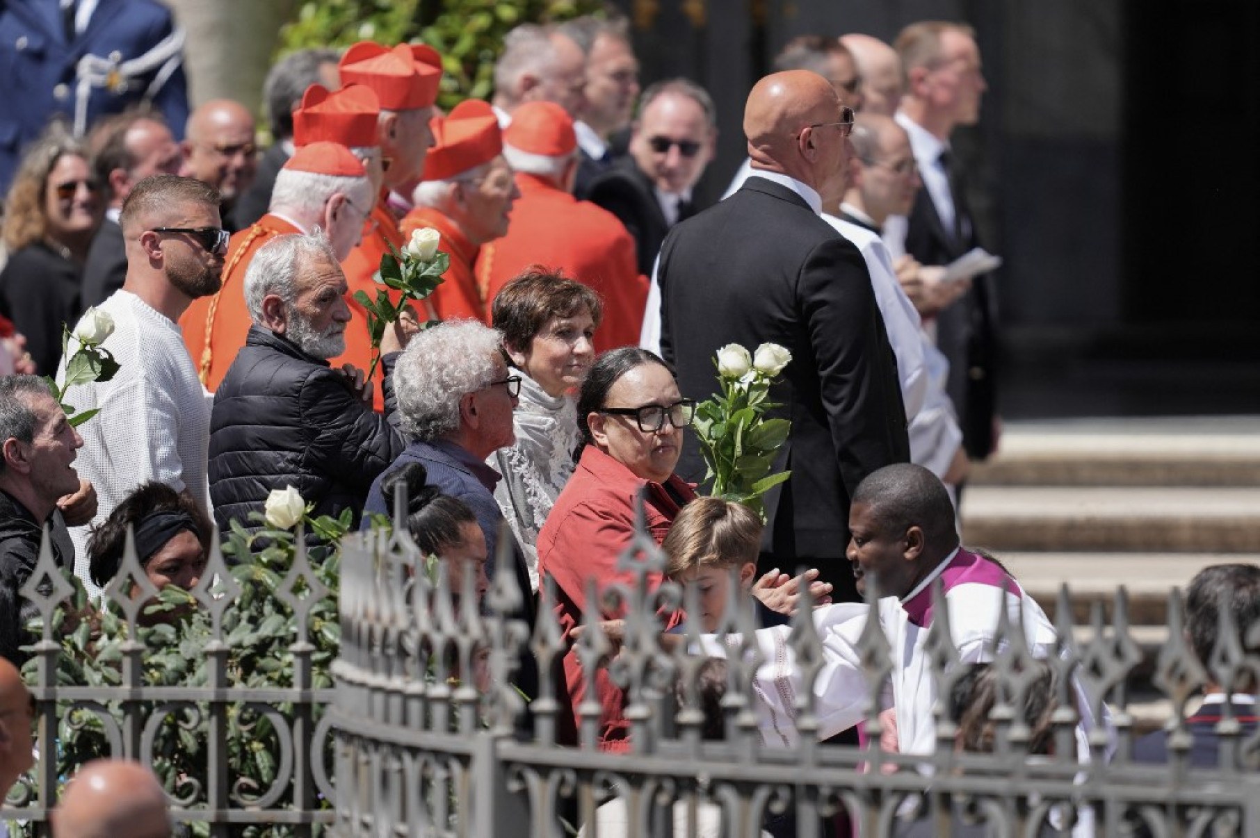 Pessoas carentes seguram rosas brancas enquanto o caixão do Papa Francisco chega para ser enterrado na Basílica de Santa Maria Maggiore-Stefano Costantino / AFP