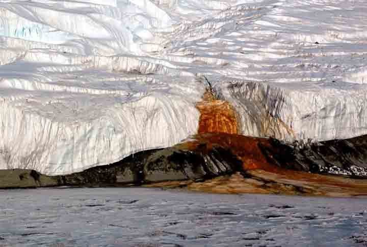 A cor vermelha da cachoeira é causada pela presença de ferro oxidado, que está dissolvido em uma solução salina subterrânea. Ele oxida quando entra em contato com o ar, resultando na cor vermelha característica.