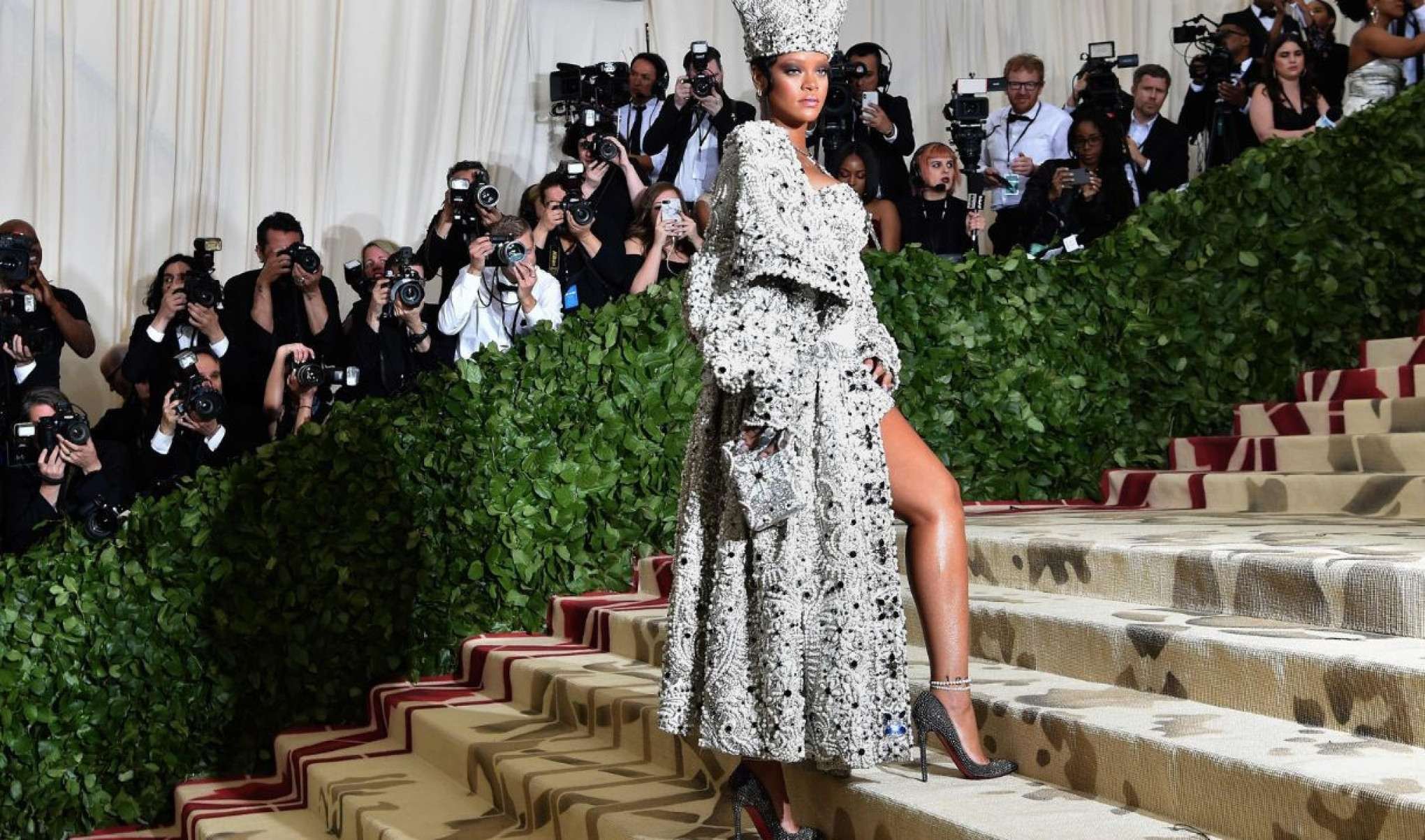 Em contraste com a simplicidade de Francisco, a cantora Rihanna apareceu no Met Gala de 2018 como uma papisa de look ousado e requintado, com brilho da cabeça aos pés-AFP