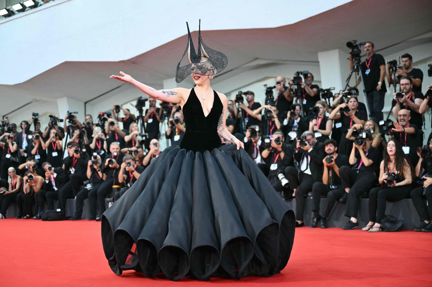 Para lançar o filme "Coringa: Delírio a dois" no Festival de Veneza 2024, a estrela escolheu modelo preto de alta-costura Christian Dior, adereço de cabeça assinado por Phlip Treacy e joias da Tiffany & Co. O filme fracassou posteriormente, mas não ofuscou Gaga.  

-Alberto Pizzoli/AFP