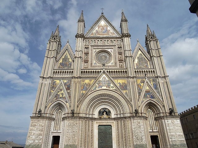 Catedral de Orvieto - Sua construção começou em 1290 e durou três séculos, com um estilo que evolui do românico para o gótico. Sua fachada é decorada por mosaicos de ouro.-Livioandronico2013 wikimedia commons 