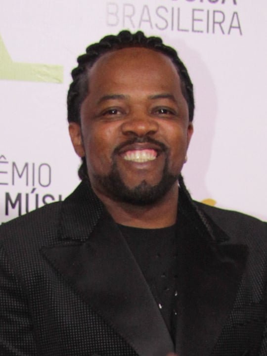 Xande de Pilares (Cantor)- O carioca nasceu em 25/12/1969, começou a carreira cantando em bares, e logo despontou como vocalista do grupo Revelação, que fez sucesso com o álbum "Ao Vivo no Olimpo"(2003), já em carreira solo se firmou como grande nome do samba nacional e acaba de lançar o projeto, "Xande canta Caetano "(2023).