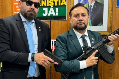 Delegado Caveira (à esquerda) posa segurando uma pistola em seu gabinete -  (crédito: Reprodução/Redes Sociais)