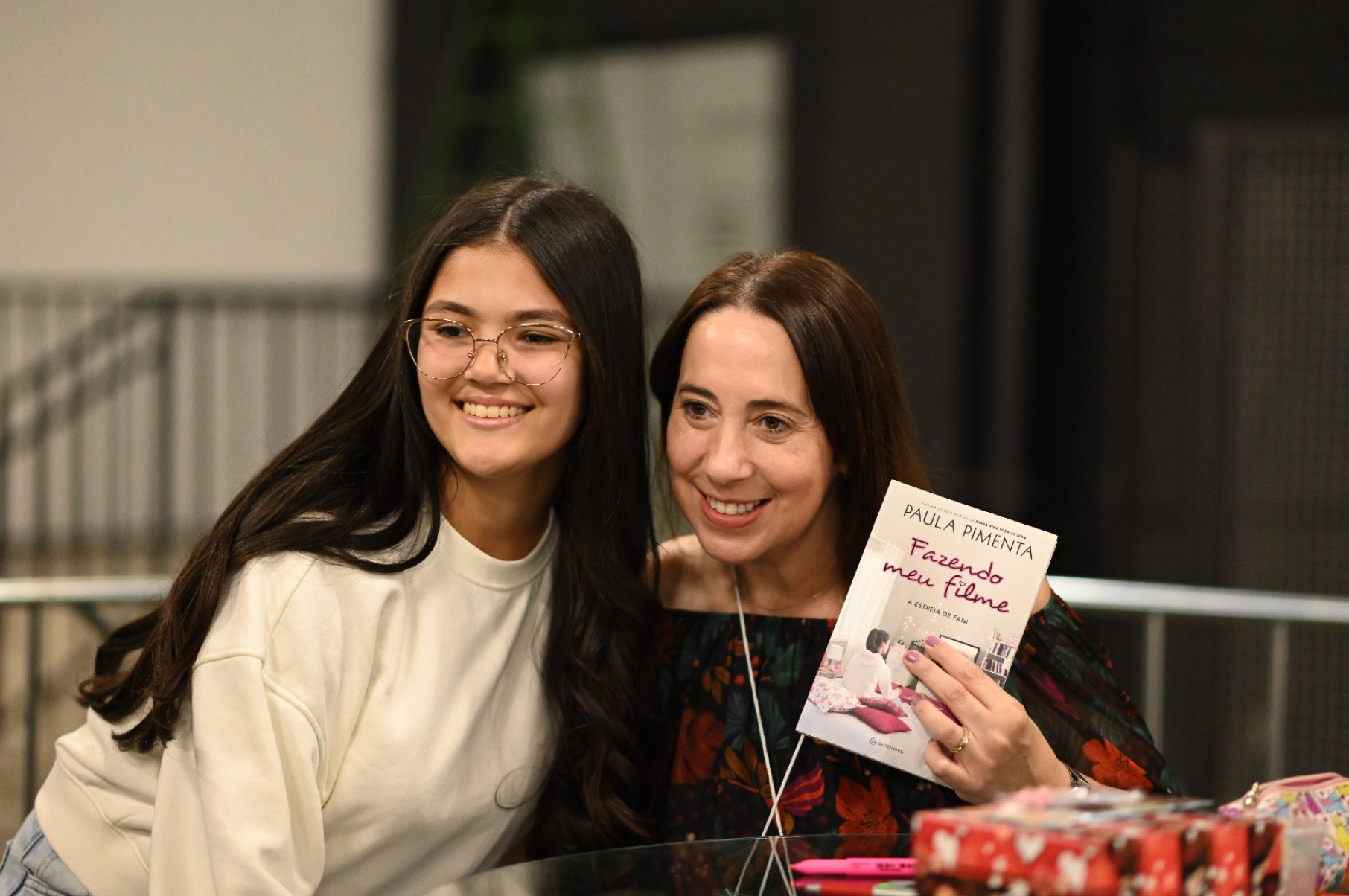 Jovem Yasmin Moutinho abraçada com a escritora Paula Pimenta na Bienal do Livro Mineiro, em BH