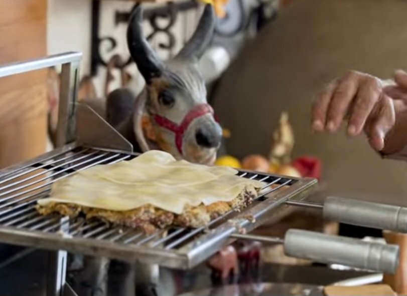 Vire a carne na grelha e cubra com muçarela.  Assim, o outro lado da carne também vai ficar tostado, enquanto o queijo derrete na parte de cima. -Reprodução YouTube Canal Churrasqueadas,