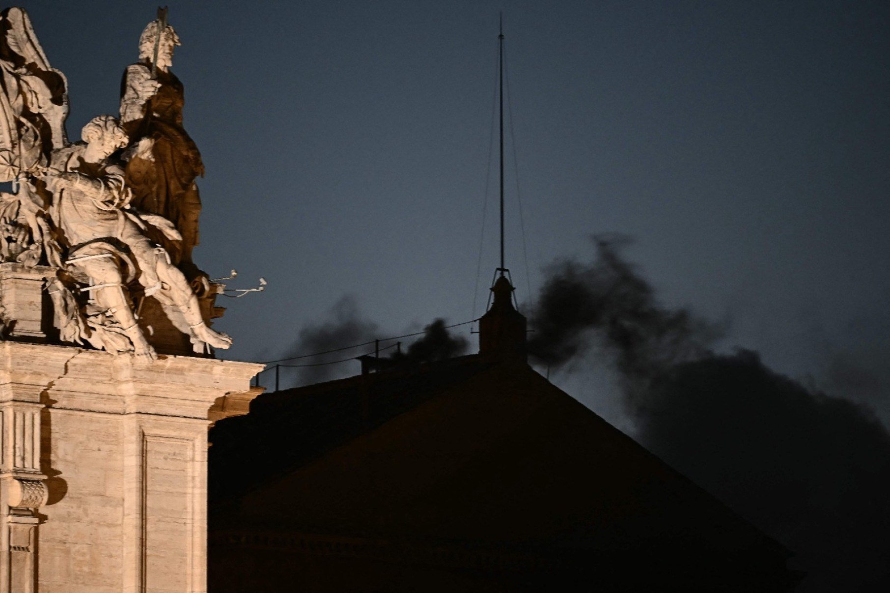 Fumaça preta sai do telhada da Capela Sistina -  (crédito: Filippo Monteforte/AFP)