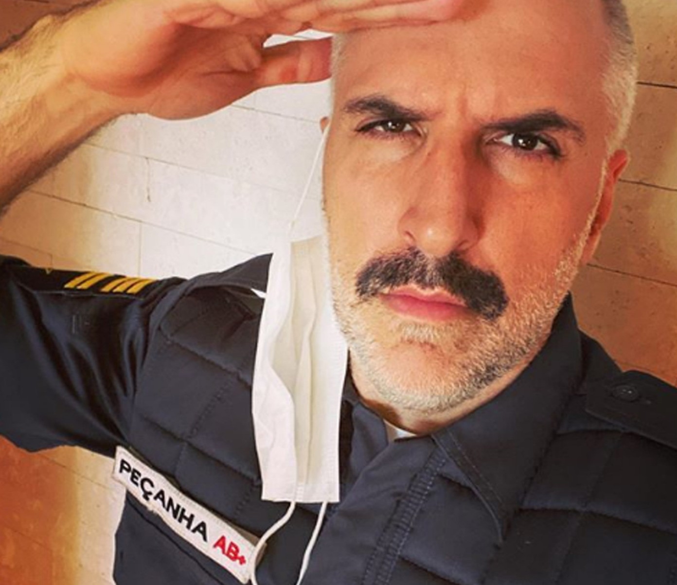 Ator Antonio Tabet faz continência e olha para a câmera