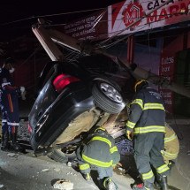 Carro bate em poste e fica 'pendurado' por fiação elétrica 