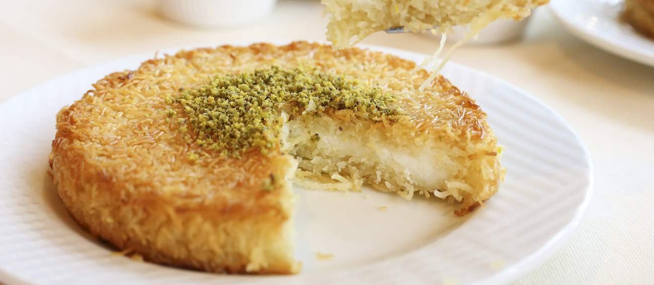 19º - Kun?fah (Egito): Consiste em duas camadas crocantes de massa kataifi ou knefe ralada e amanteigada, recheada com um delicioso creme de queijo que geralmente é aromatizado com raspas de laranja e cardamomo. Depois, é embebido em xarope de açúcar com suco de limão e água de flor de laranjeira.