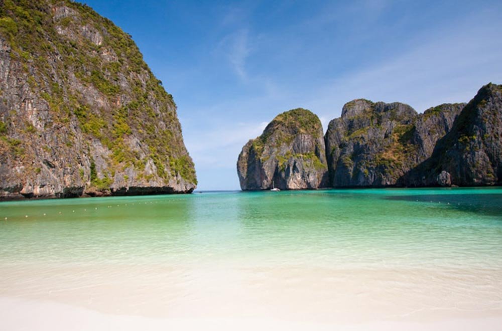 Maya Bay (TailÃ¢ndia): Cercada por falÃ©sias e protegida por uma enseada, essa praia tem um mar calmo e raso, ideal para nadar sem preocupaÃ§Ãµes.