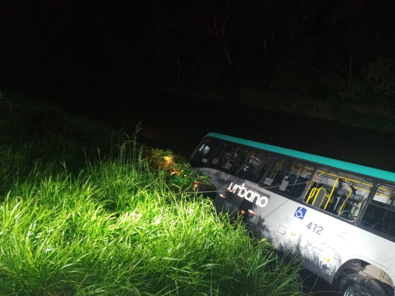 Ônibus ficou tombado às margens do Rio Paraibuna