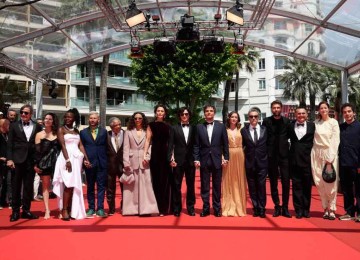 Elenco do filme 'O agente secreto' caminhou até chegar ao tapete vermelho, ao som do frevo pernambucano -  (crédito: Valery Hache/AFP)
