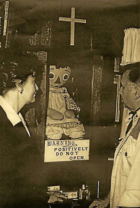 Na casa, a grande sensação é justamente a boneca Annabelle, sempre trancada numa redoma (com o aviso de que a porta não deve ser aberta)  e recebendo água benta com frequência. Na foto, Ed e Lorraine com a boneca - Imagem do site macabra Tv